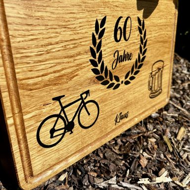 Holztafel mit Inschrift "60 Jahre" und Symbolen für ein Fahrrad und ein Bierglas.